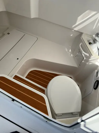  Yacht Photos Pics Interior of 2023 Edgewater 285CC boat featuring a compact marine toilet.