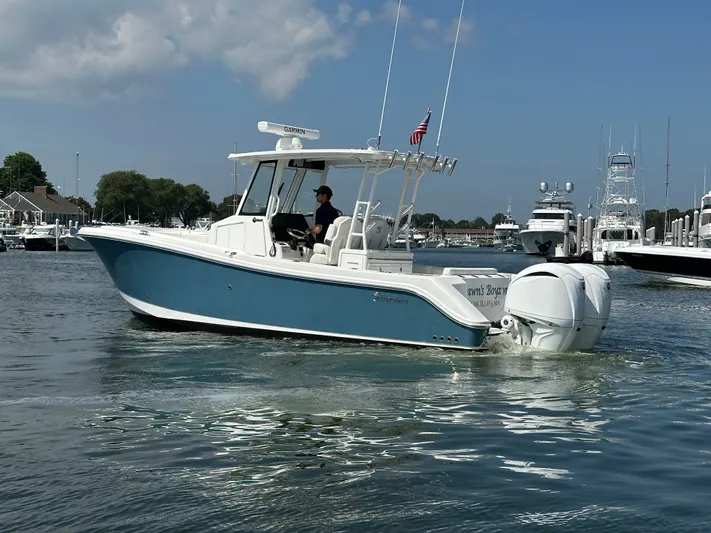  Yacht Photos Pics 2023 Edgewater 285CC boat cruising in a marina with clear skies.