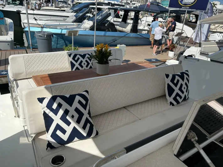  Yacht Photos Pics Luxurious seating area on 2024 Jeanneau DB43 yacht with decorative pillows and table.
