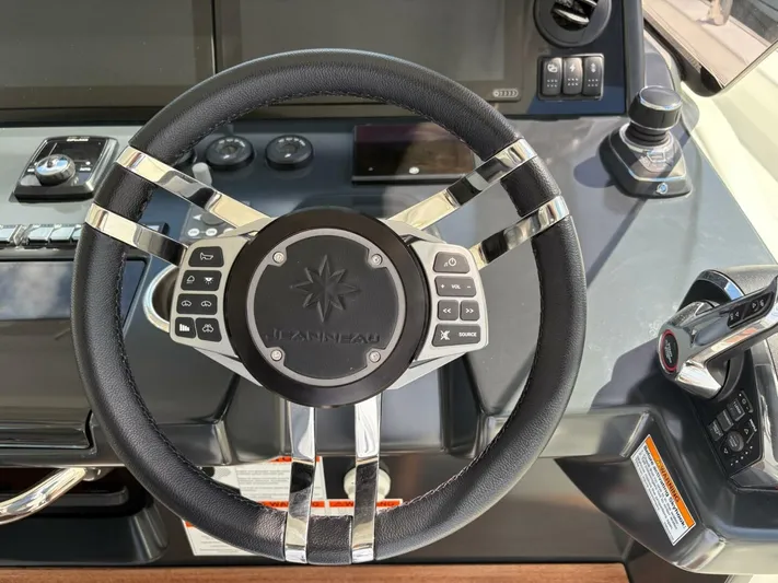  Yacht Photos Pics Steering wheel of 2024 Jeanneau DB43 boat with control buttons and dashboard.