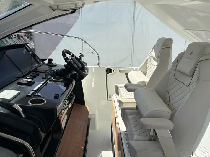  Yacht Photos Pics 2024 Jeanneau DB43 helm with modern controls and luxurious seating.