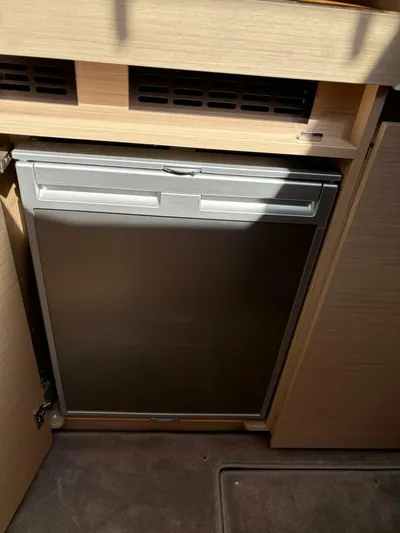  Yacht Photos Pics Compact refrigerator in the 2024 Jeanneau DB43 yacht interior kitchen area.