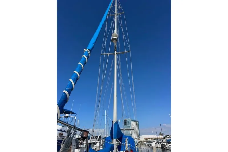 Southern Cross Yacht Photos Pics 1987 Tayana Vancouver 42 sailboat with blue sails docked at marina under clear sky.