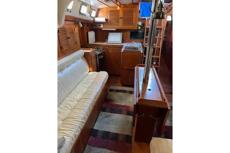 Southern Cross Yacht Photos Pics 1987 Tayana Vancouver 42 yacht interior with wood finish, white seating, and kitchen area.