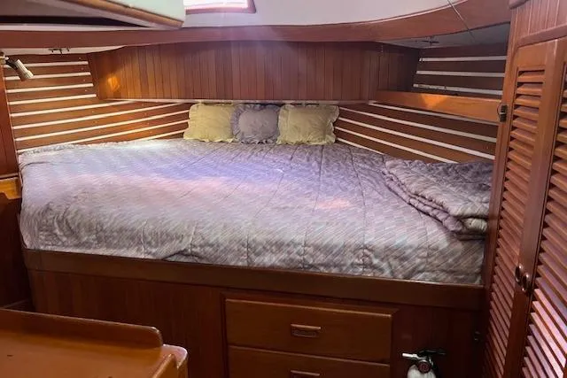 Southern Cross Yacht Photos Pics Cozy cabin interior of 1987 Tayana Vancouver 42 sailboat with wooden paneling and bed.