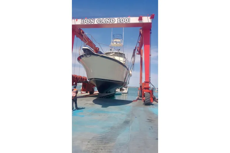 Abuelo Yacht Photos Pics 1989 HATTERES Convertible boat lifted by crane at dockside.