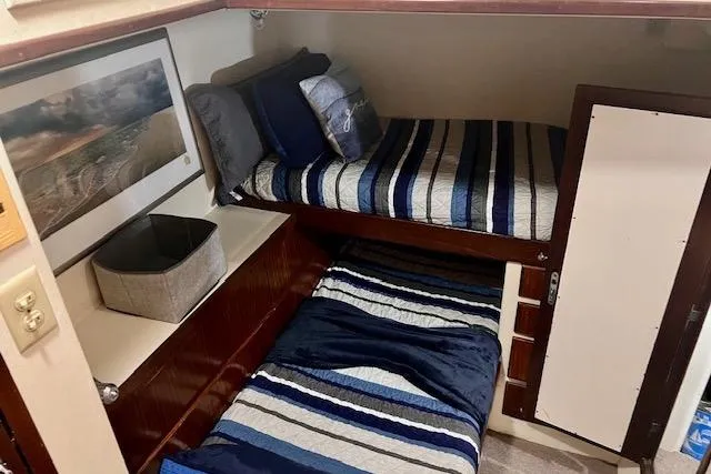 Abuelo Yacht Photos Pics 1989 HATTERES Convertible cabin with striped bedding and wall art.