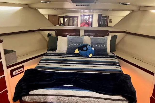 Abuelo Yacht Photos Pics 1989 HATTERES Convertible yacht interior with cozy bed and plush pillows.