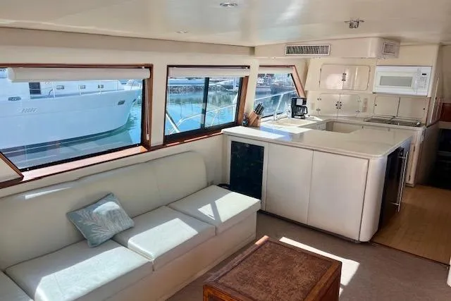 Abuelo Yacht Photos Pics Interior of 1989 HATTERES Convertible yacht with white sofa and modern kitchen.