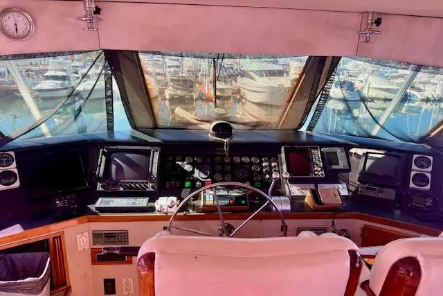 Abuelo Yacht Photos Pics 1989 HATTERES Convertible yacht cockpit with navigation instruments and marina view.