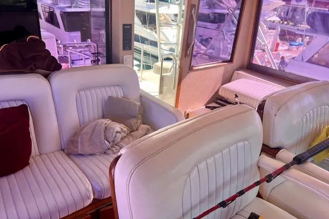 Abuelo Yacht Photos Pics Interior of 1989 HATTERES Convertible yacht with white seating and fishing rod.
