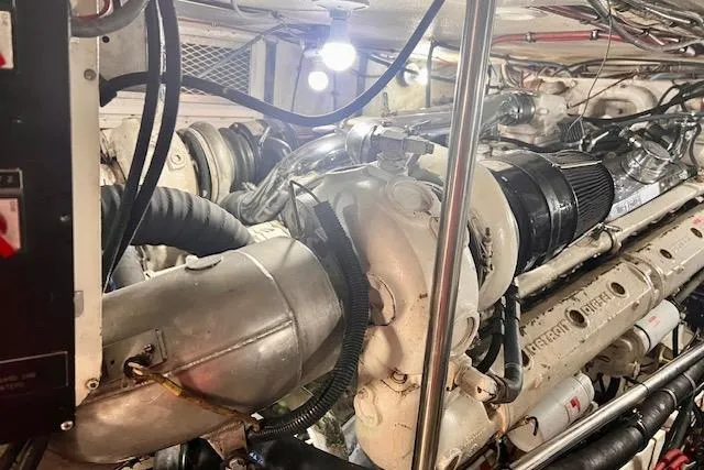 Abuelo Yacht Photos Pics Engine room of a 1989 HATTERES Convertible boat, showcasing mechanical components and piping.