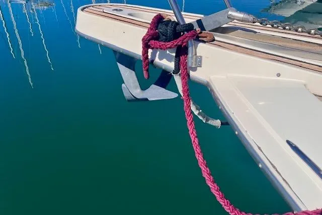 Abuelo Yacht Photos Pics 1989 HATTERES Convertible boat with anchor and red rope on calm water.