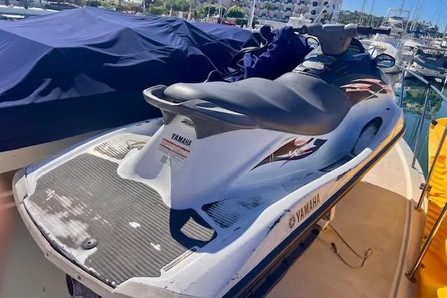 Abuelo Yacht Photos Pics Yamaha jet ski on a docked 1989 HATTERES Convertible boat in a marina.