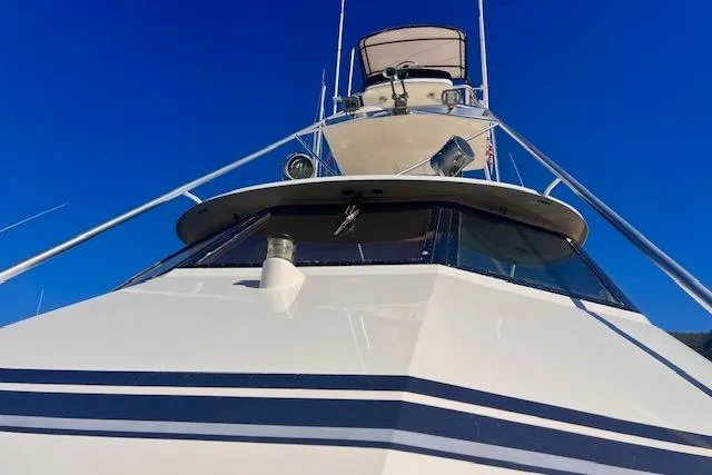 Abuelo Yacht Photos Pics 1989 HATTERES Convertible yacht against clear blue sky, showcasing sleek design and structure.