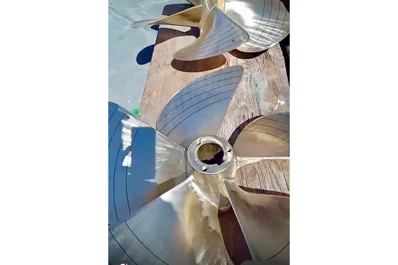 Abuelo Yacht Photos Pics 1989 HATTERES Convertible boat propeller on wooden surface, showcasing metallic blades.