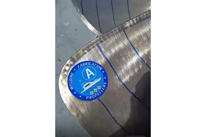 Abuelo Yacht Photos Pics Close-up of a 1989 HATTERES Convertible propeller with a blue welding and fabrication sticker.