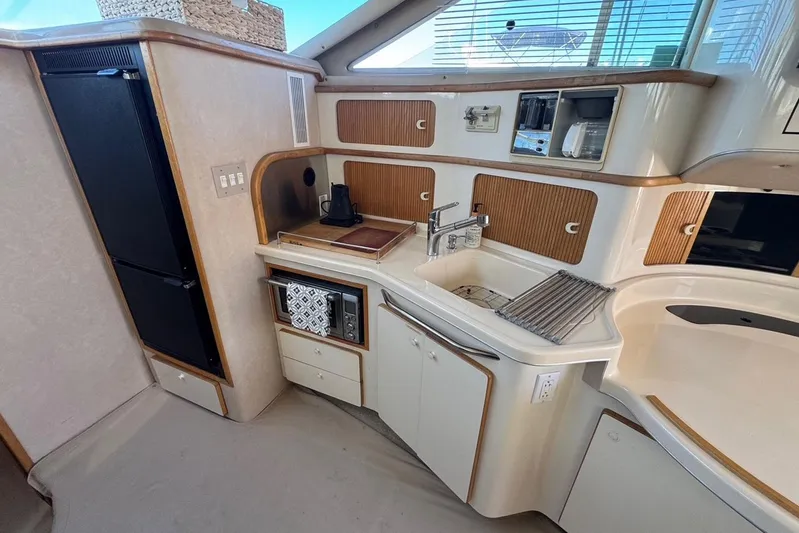 Pearl Yacht Photos Pics 1994 Sea Ray 440 Express Bridge yacht kitchen with modern appliances and wood accents.
