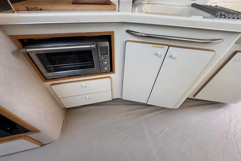 Pearl Yacht Photos Pics 1994 Sea Ray 440 Express Bridge kitchen with built-in oven and storage cabinets.