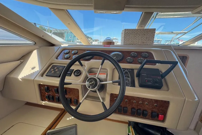 Pearl Yacht Photos Pics 1994 Sea Ray 440 Express Bridge helm with steering wheel and control panel.