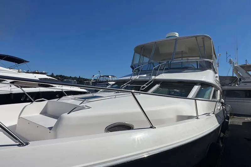 Pearl Yacht Photos Pics 1994 Sea Ray 440 Express Bridge yacht docked under clear blue sky.