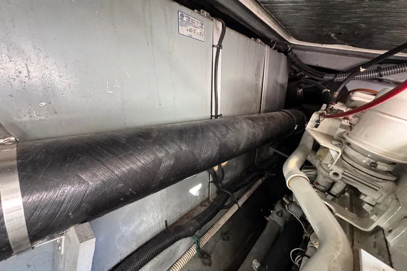 Pearl Yacht Photos Pics Engine room of a 1994 Sea Ray 440 Express Bridge, showcasing mechanical components and piping.