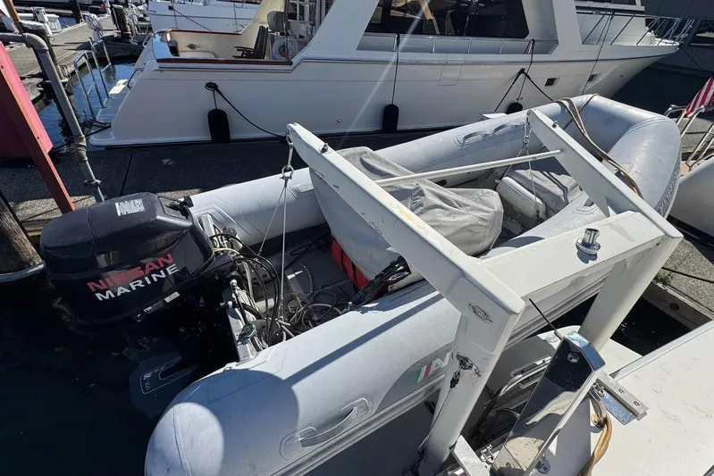 Pearl Yacht Photos Pics 1994 Sea Ray 440 Express Bridge with inflatable boat and Nissan Marine motor at dock.