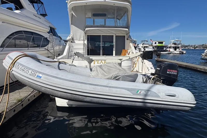 Pearl Yacht Photos Pics 1994 Sea Ray 440 Express Bridge yacht docked with inflatable boat attached.