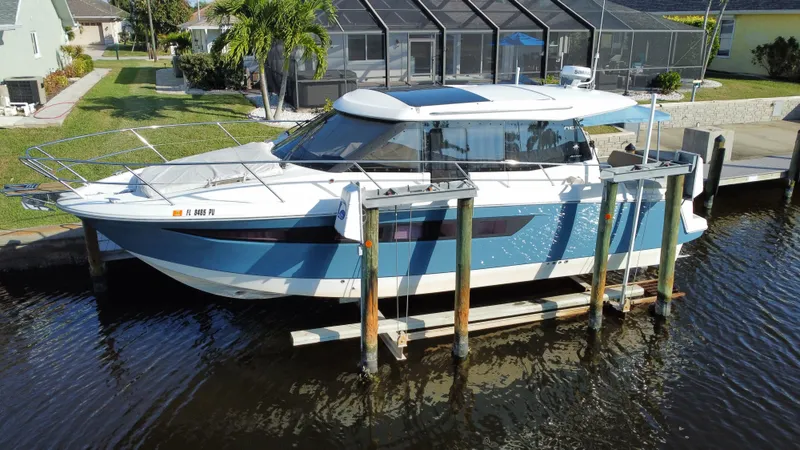 Funkytown 2 Yacht Photos Pics 2014 Jeanneau NC 11 boat docked on a lift in a residential canal.
