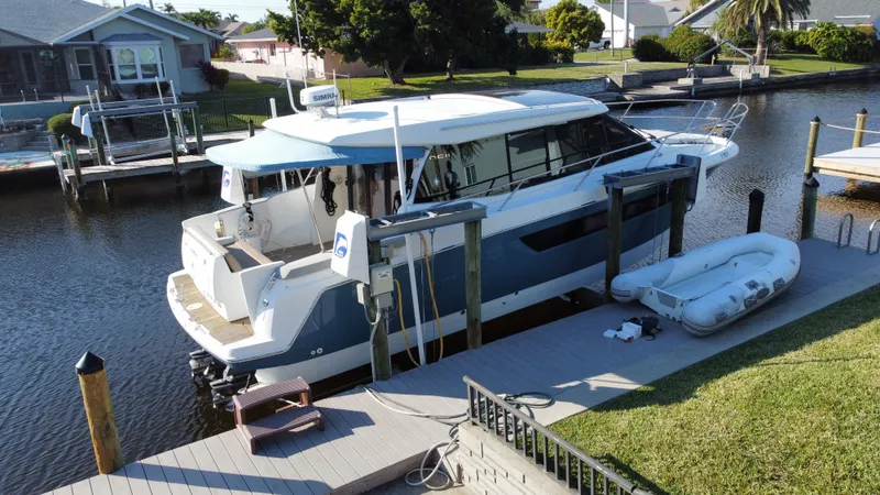 Funkytown 2 Yacht Photos Pics 2014 Jeanneau NC 11 docked by a canal with an inflatable boat nearby.