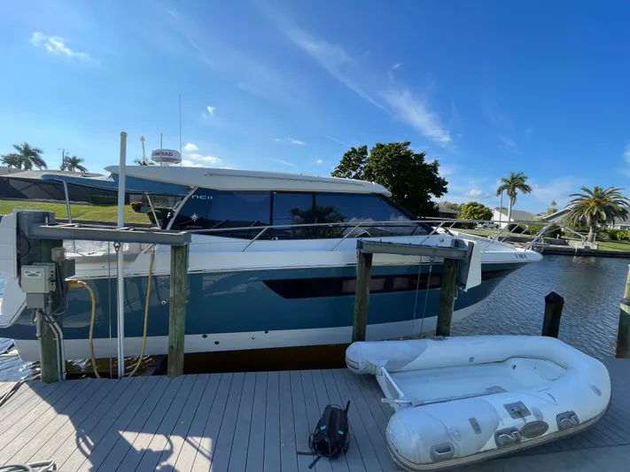 Funkytown 2 Yacht Photos Pics 2014 Jeanneau NC 11 yacht docked beside inflatable boat, under clear blue sky.