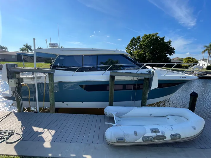 Funkytown 2 Yacht Photos Pics 2014 Jeanneau NC 11 yacht docked with inflatable boat, under clear blue sky.