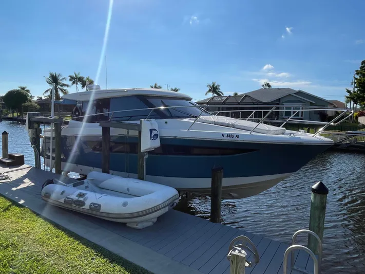 Funkytown 2 Yacht Photos Pics 2014 Jeanneau NC 11 boat docked by waterfront with inflatable dinghy nearby.