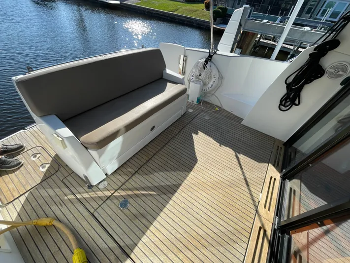 Funkytown 2 Yacht Photos Pics 2014 Jeanneau NC 11 boat deck with seating, docked by the water.
