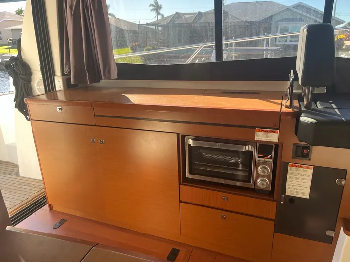 Funkytown 2 Yacht Photos Pics Interior of 2014 Jeanneau NC 11 boat with wooden cabinetry and built-in oven.