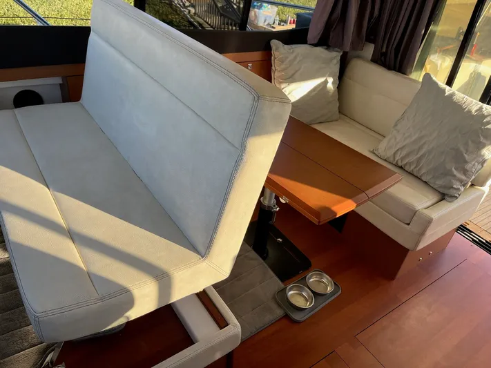 Funkytown 2 Yacht Photos Pics Interior of 2014 Jeanneau NC 11 boat with cushioned seating and wooden table.