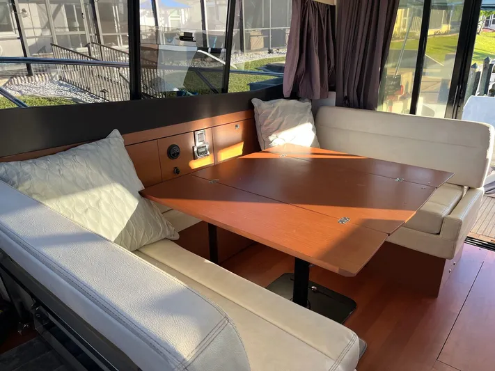 Funkytown 2 Yacht Photos Pics Interior of 2014 Jeanneau NC 11 boat with cozy seating and wooden table.