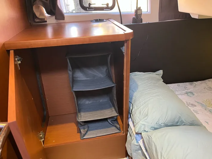 Funkytown 2 Yacht Photos Pics Interior of 2014 Jeanneau NC 11 showing a wooden cabinet and bed with blue bedding.