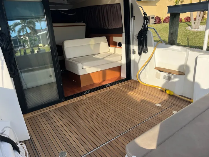 Funkytown 2 Yacht Photos Pics 2014 Jeanneau NC 11 boat interior with wooden deck and seating area.