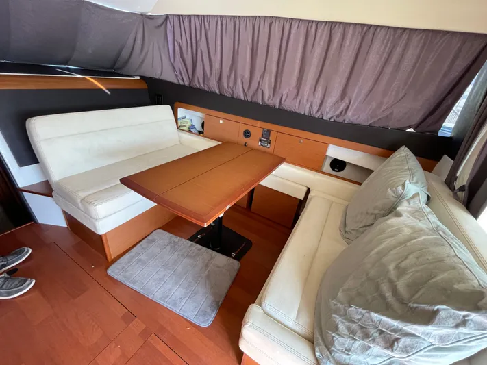 Funkytown 2 Yacht Photos Pics Interior of 2014 Jeanneau NC 11 yacht with cozy seating and wooden table.