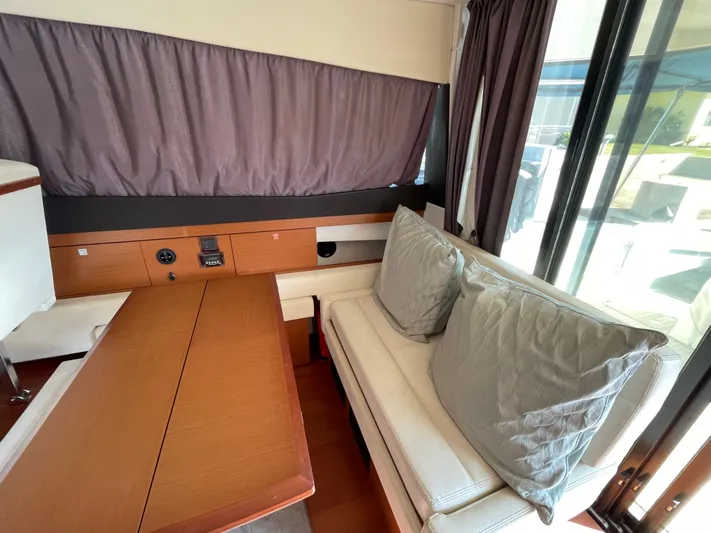 Funkytown 2 Yacht Photos Pics Interior of 2014 Jeanneau NC 11 yacht with cozy seating and wooden table.