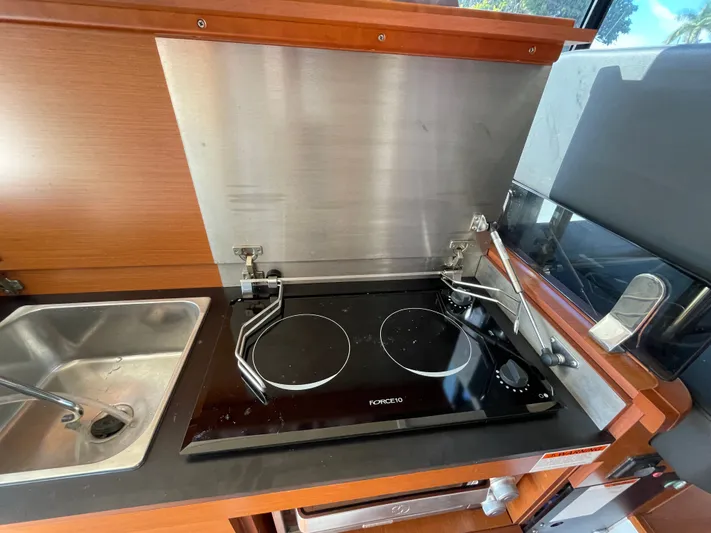 Funkytown 2 Yacht Photos Pics Compact kitchen area in a 2014 Jeanneau NC 11 boat with stove and sink.