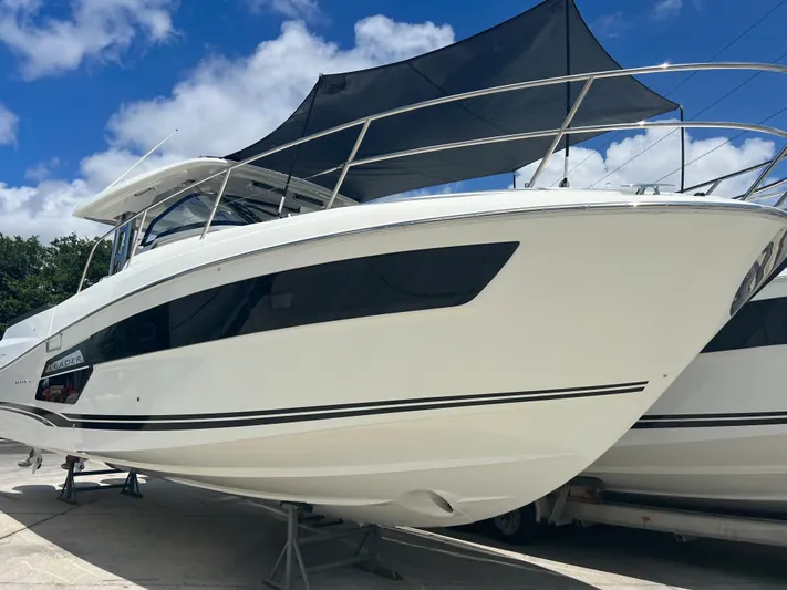 Jeanneau Yacht Photos Pics 2024 Jeanneau 12.5 Walk boat with sleek design under a blue sky.