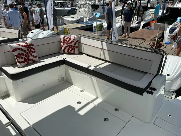 Jeanneau Yacht Photos Pics 2024 Jeanneau 12.5 Walk boat interior with cushioned seating and decorative pillows.