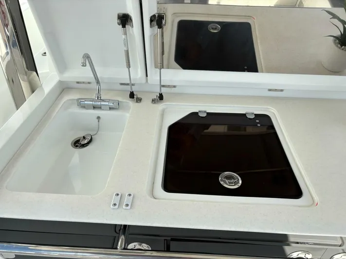 Jeanneau Yacht Photos Pics 2024 Jeanneau 12.5 Walk kitchen area with sink and covered stove.