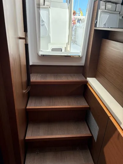 Jeanneau Yacht Photos Pics 2024 Jeanneau 12.5 Walk interior stairs with wooden finish and open hatch.