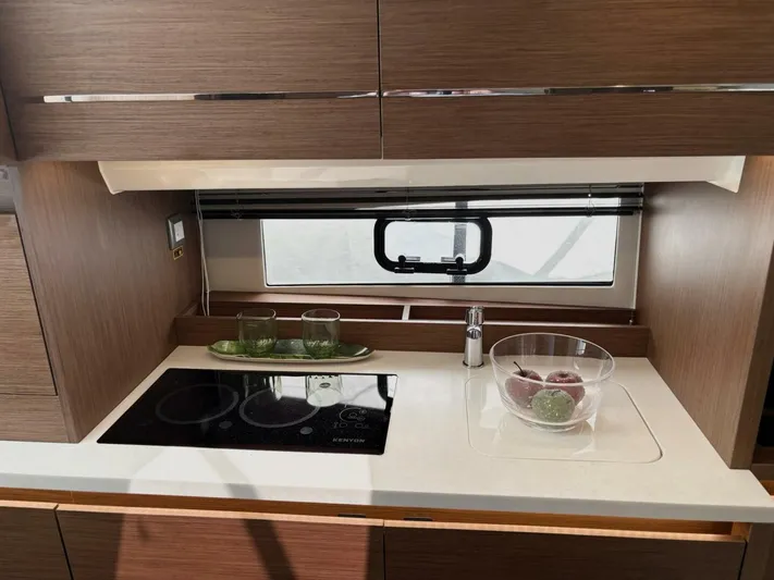 Jeanneau Yacht Photos Pics Modern kitchen area in 2024 Jeanneau 12.5 Walk, featuring sleek design and appliances.