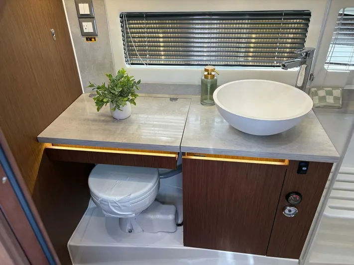 Jeanneau Yacht Photos Pics 2024 Jeanneau 12.5 Walk bathroom with modern sink, toilet, and stylish decor.