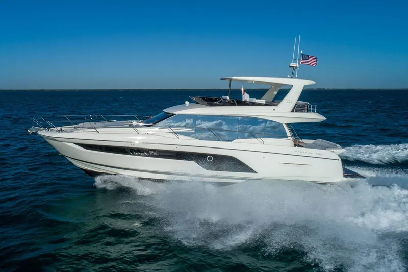  Yacht Photos Pics Manufacturer Provided Image: 2024 Prestige 590 yacht cruising on open water under clear blue skies.