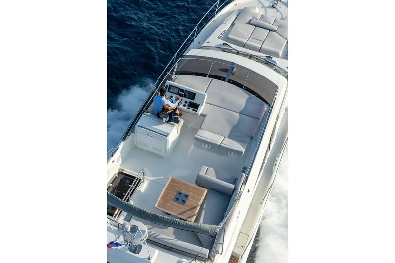  Yacht Photos Pics Manufacturer Provided Image: 2024 Prestige 590 yacht cruising on open water, top view of deck and seating area.